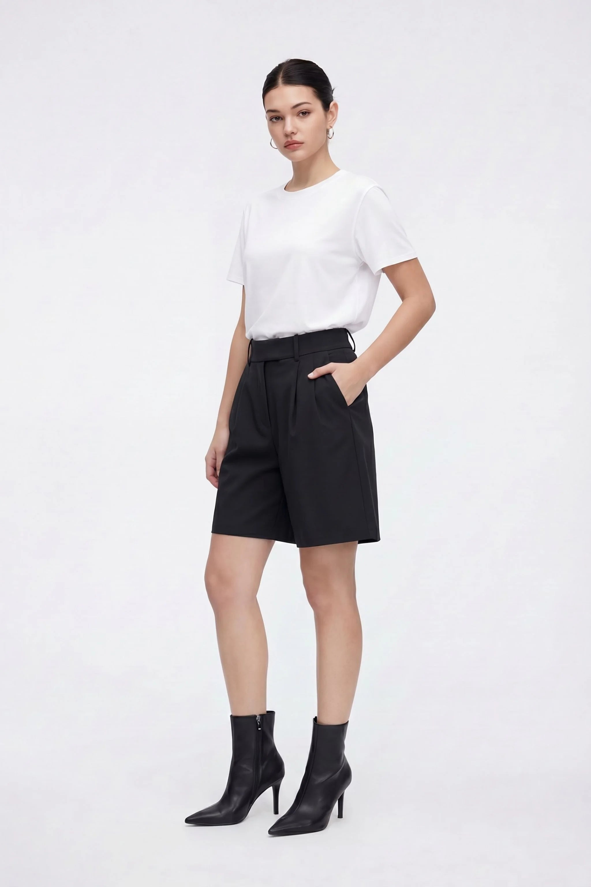 Woman wearing a white t-shirt and black shorts on a white background