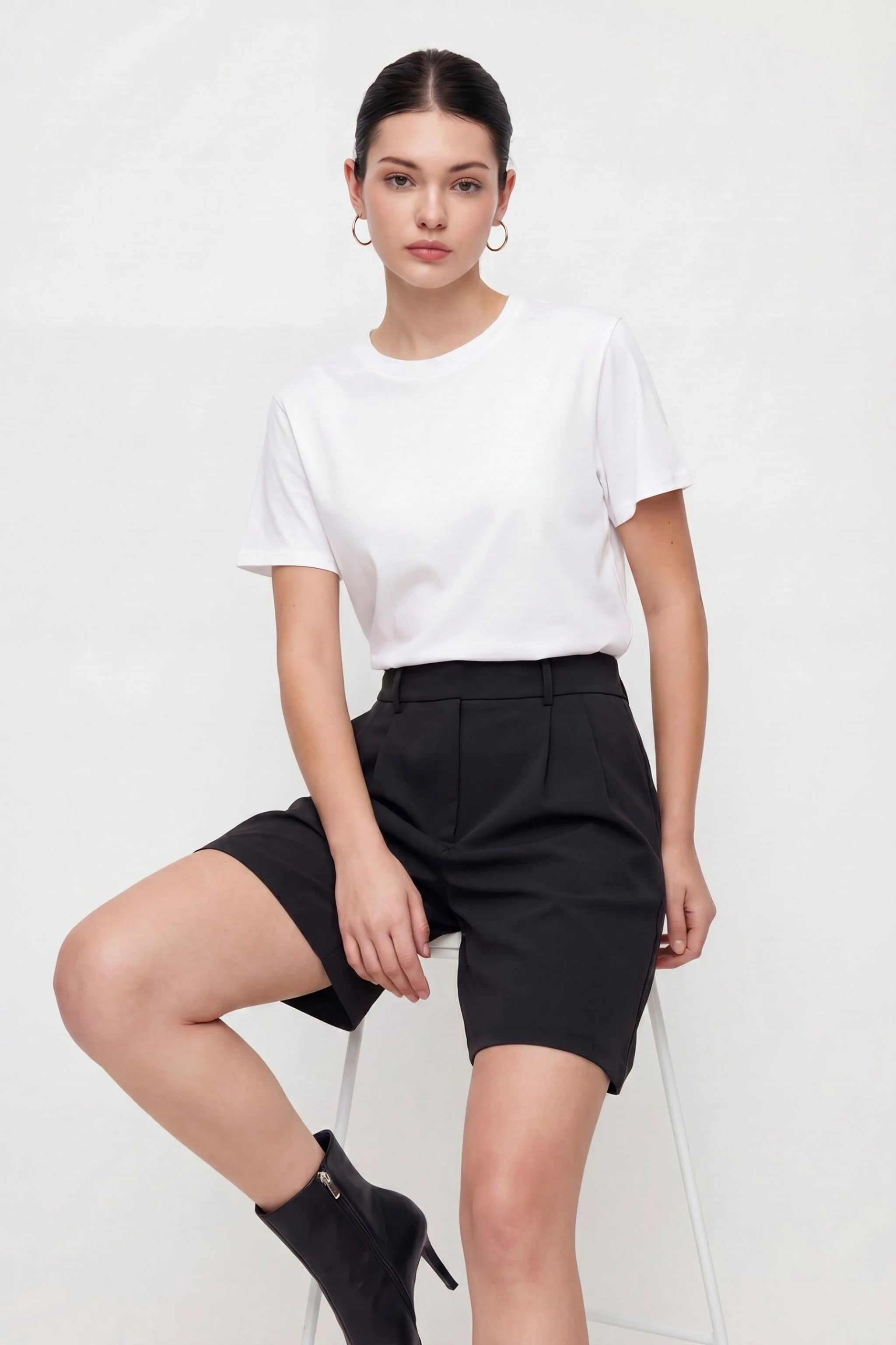 Woman wearing a white t-shirt and black shorts on a white background