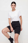 Woman wearing a white t-shirt and black shorts on a white background